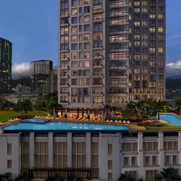 A modern high-rise building with balconies overlooks an outdoor swimming pool area, surrounded by cityscape and other tall buildings.