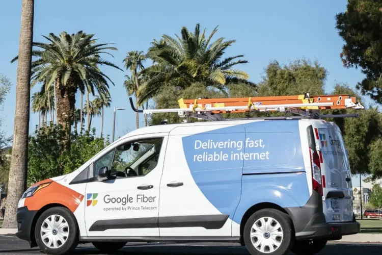 A Google Fiber service van with ladders on the roof is parked outdoors near palm trees, displaying the slogan 