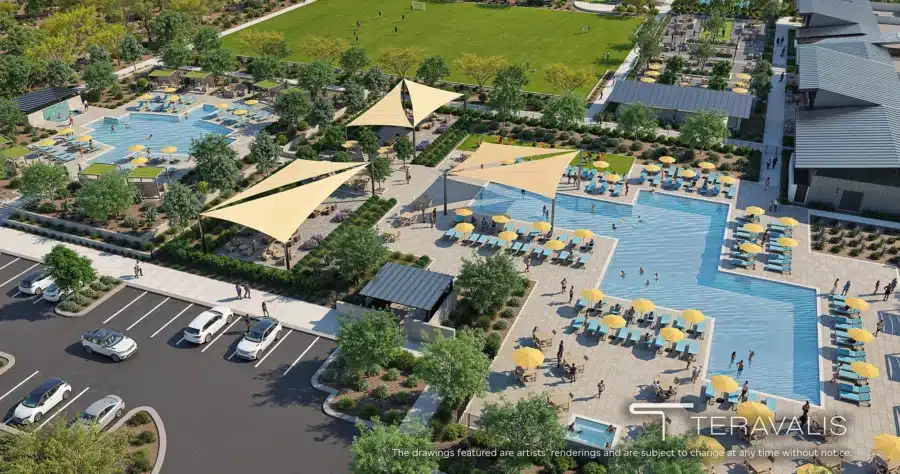 Aerial view of a community pool area with multiple pools, lounge chairs, yellow umbrellas, shaded canopies, landscaped greenery, and adjacent parking lot.